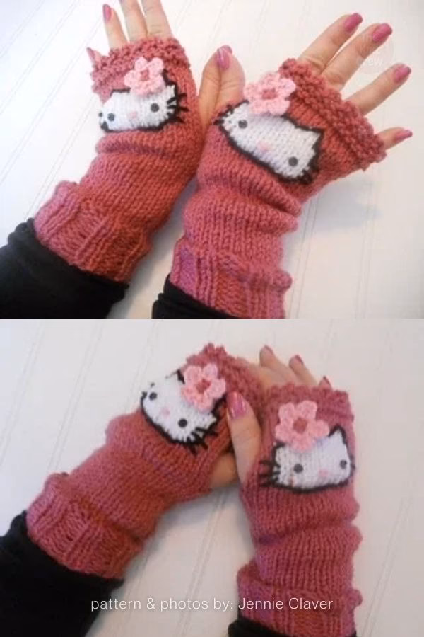 A pair of dusty rose knitted fingerless mitts being worn, showcased in a curated collection from The Knit Crew. The mitts feature a textured ribbed wrist and a scalloped crochet edge at the fingers. Each glove is decorated with a white knit Hello Kitty applique, complete with black whiskers and a small light pink crochet flower instead of a traditional bow.