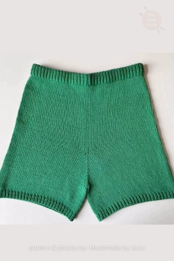 A close-up view of bright green knitted adult shorts featuring a standard ribbed waistband and ribbed leg cuffs. Curated by Ariana of TheKnitCrew.