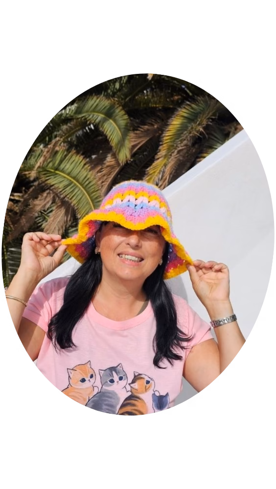 Ariana @thyarncrew, blog post curator, smiling in a colorful crochet bucket hat and a pink cat t-shirt.